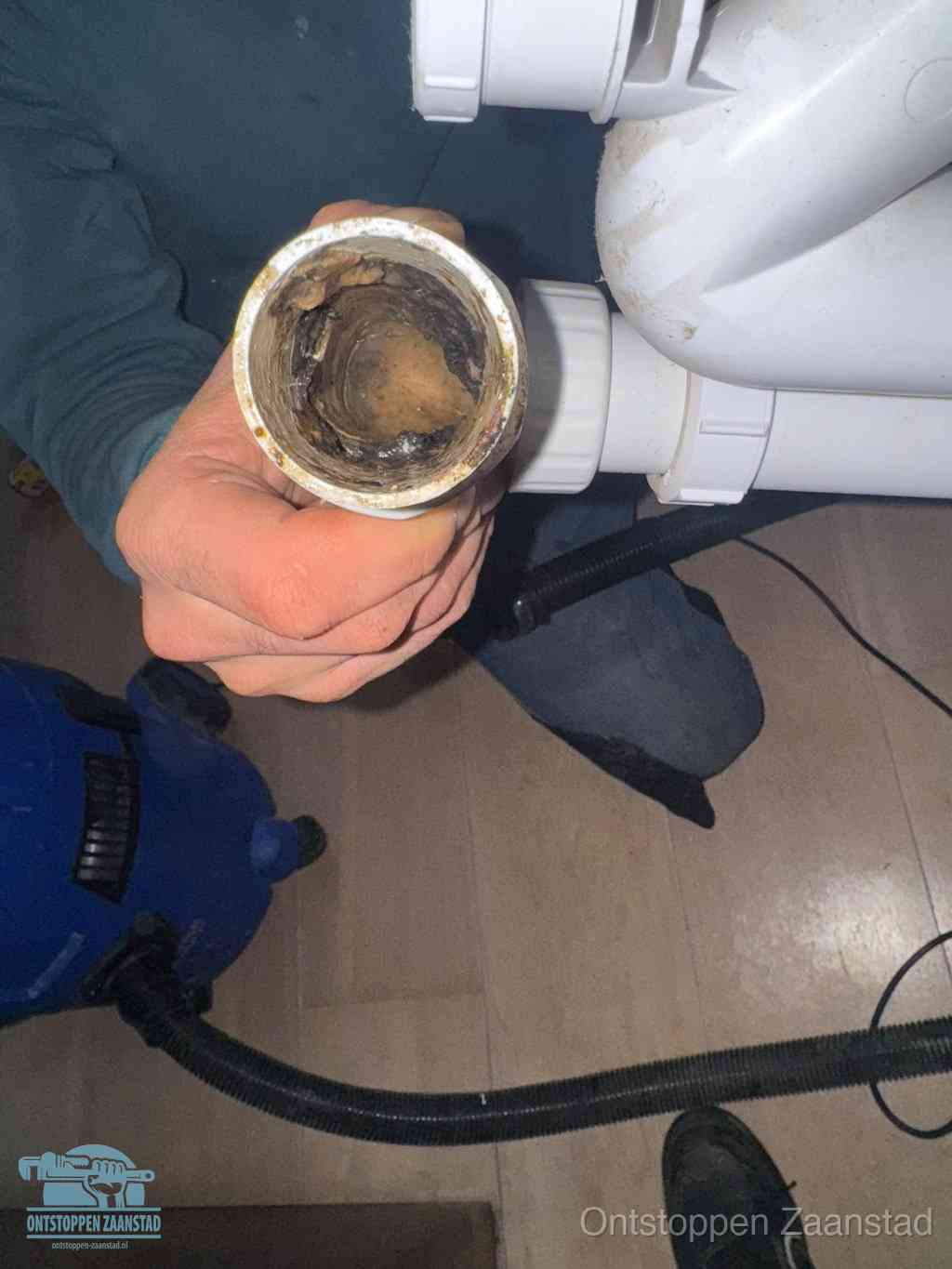 Een losgekoppeld afvoerbuisstuk dat van binnen volledig is dichtgeslibd, het gevolg van een verstopping te lang laten zitten in Zaanstad