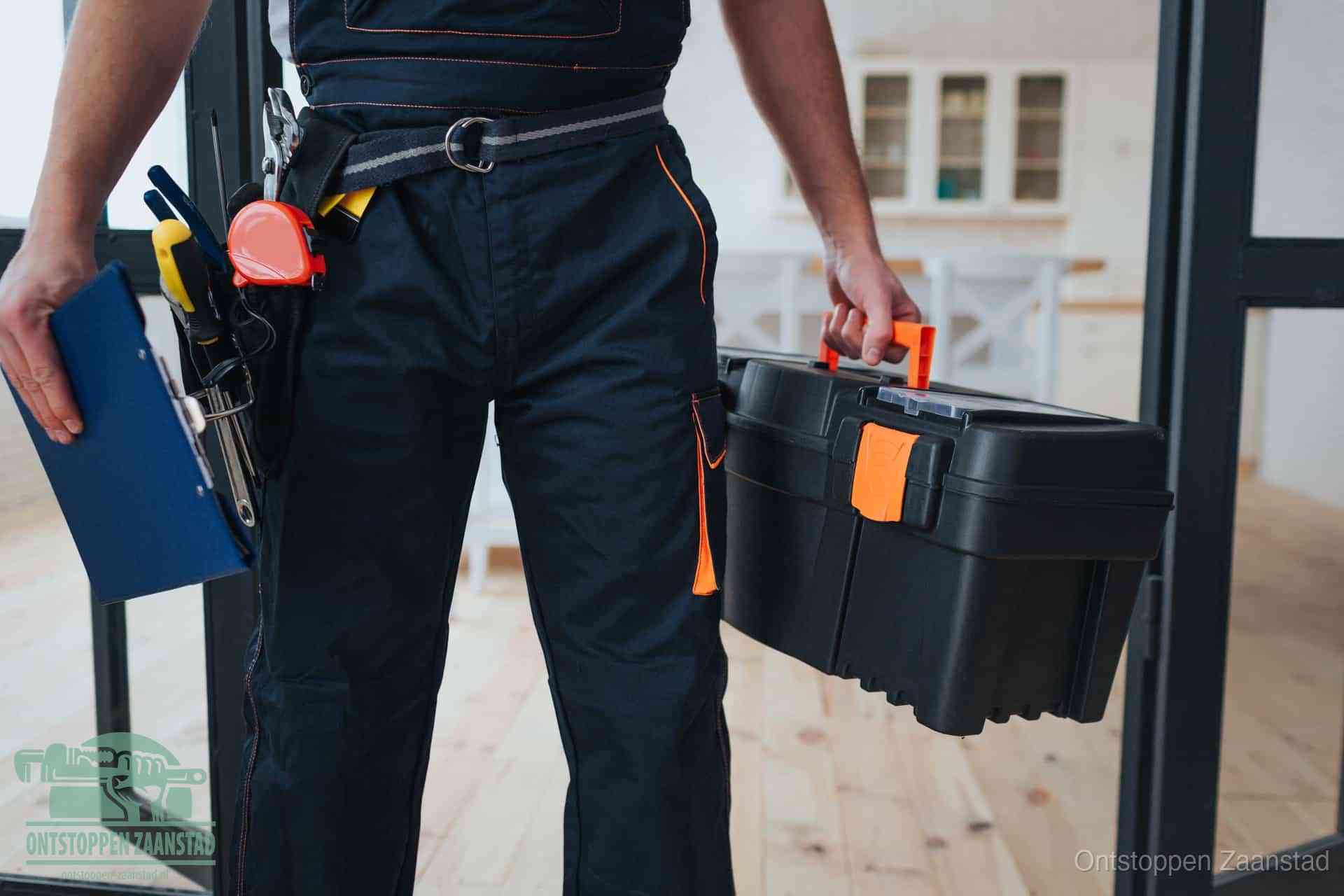 Een monteur met gereedschapsriem en klembord, klaar om een transparante prijs voor het afvoer ontstoppen in Zaanstad te geven