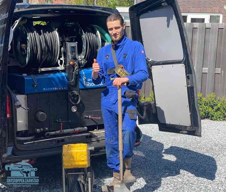 Monteur met duim omhoog bij de rioolreinigingsbus, duidelijke kosten voor riool ontstoppen in Zaanstad