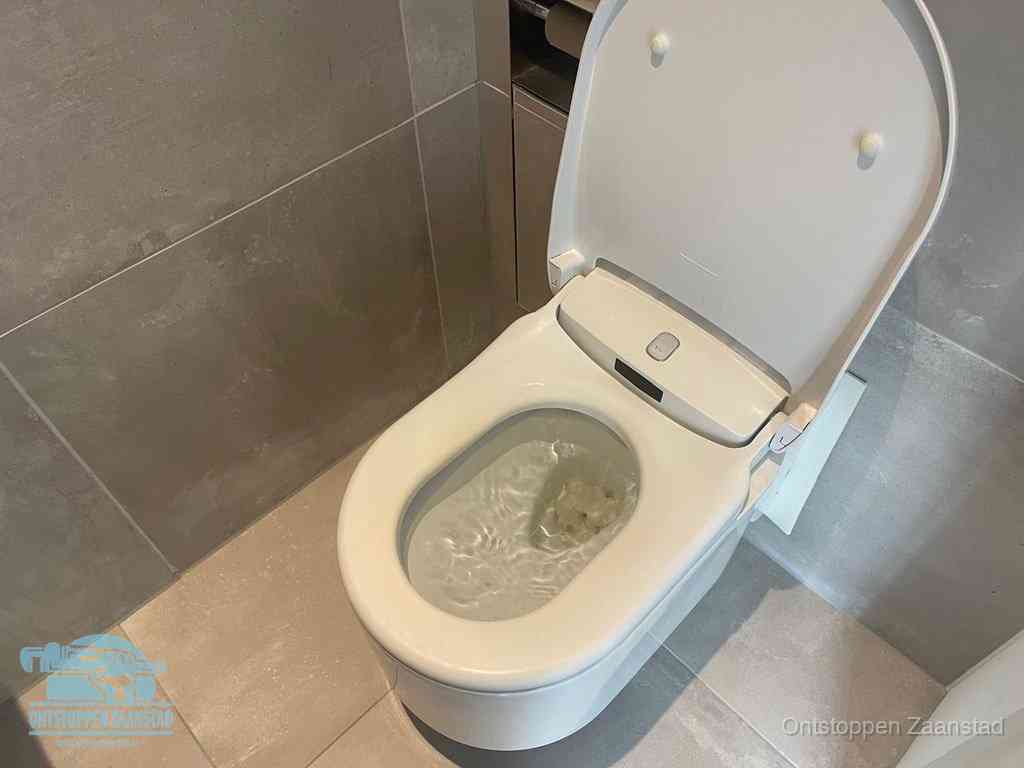 Een toiletpot vol troebel water met drijvend papier en restanten, de meest voorkomende oorzaak van een verstopte wc in Zaanstad