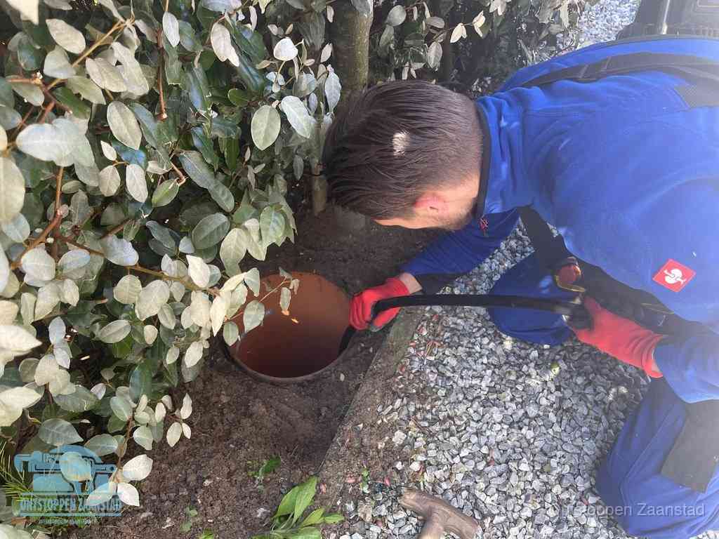 Monteur reinigt een rioolput met een slang, periodieke rioolreiniging in Zaanstad
