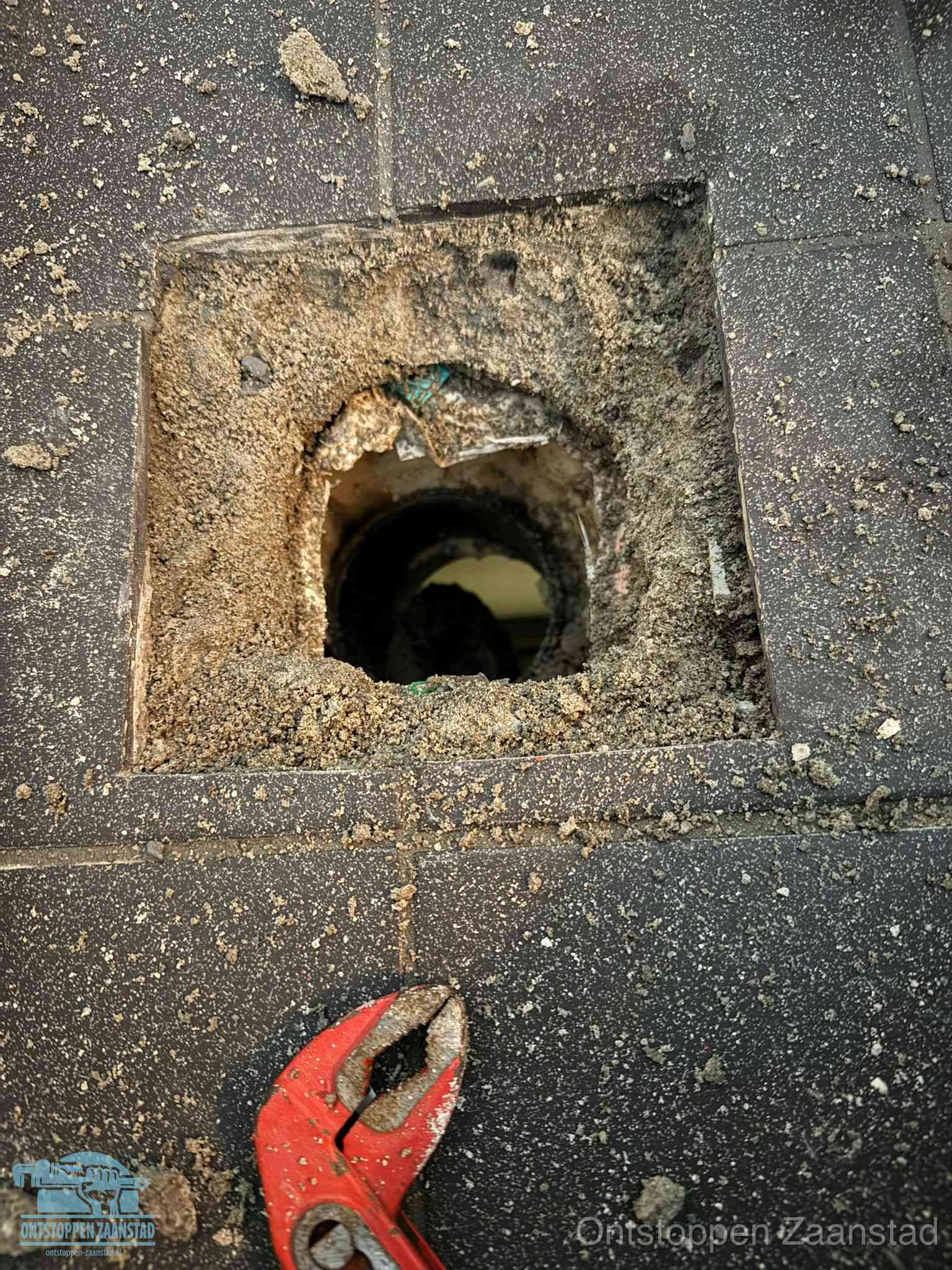 Geopend rioolputje op de erfgrens dat laat zien wie eigenaar is van de riolering in Zaanstad