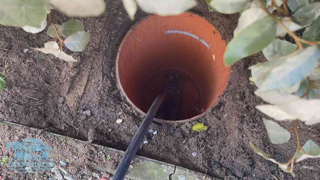 Open inspectieput in de tuin waar een veer rioolvliegjes en stankoverlast aanpakt in Zaanstad