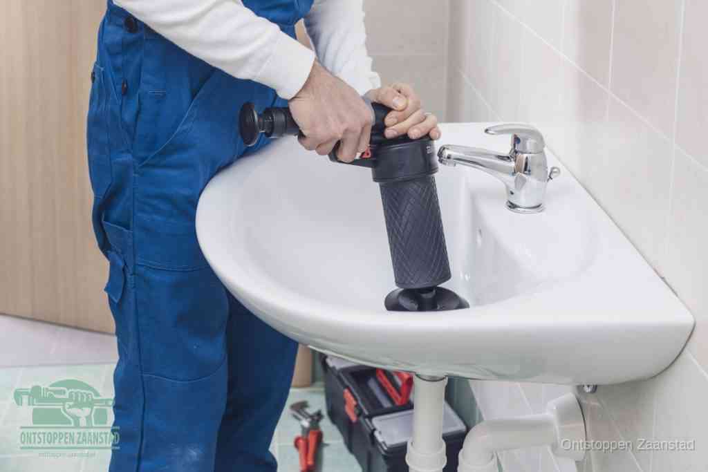 Een te ruwe doe-het-zelf poging met een hand-pomp op de afvoer van een badkamer-wastafel, een van de veelgemaakte fouten bij afvoer ontstoppen in Zaanstad