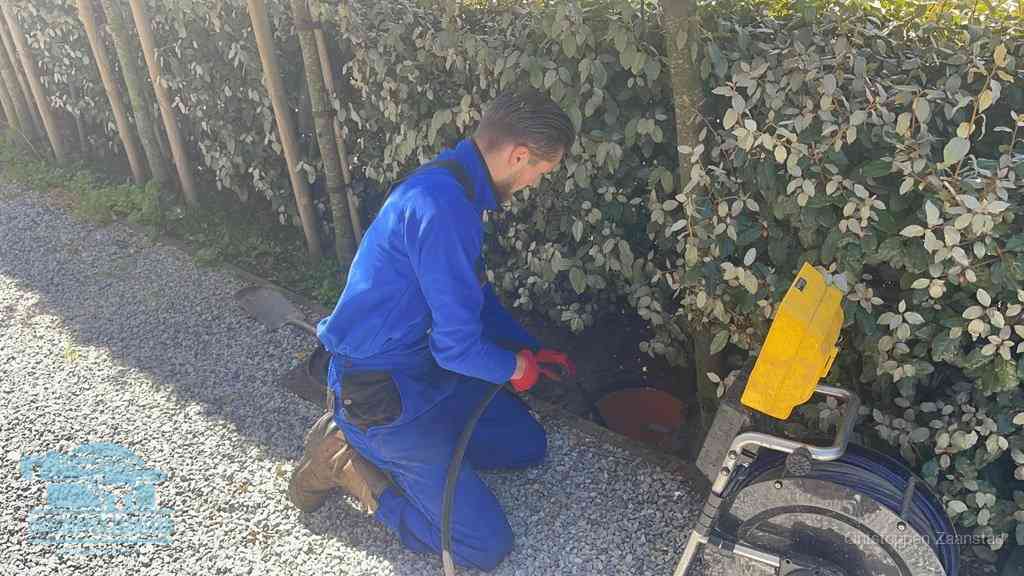 Monteur aan het werk bij een rioolput, de werkwijze voor riool ontstoppen in Zaanstad
