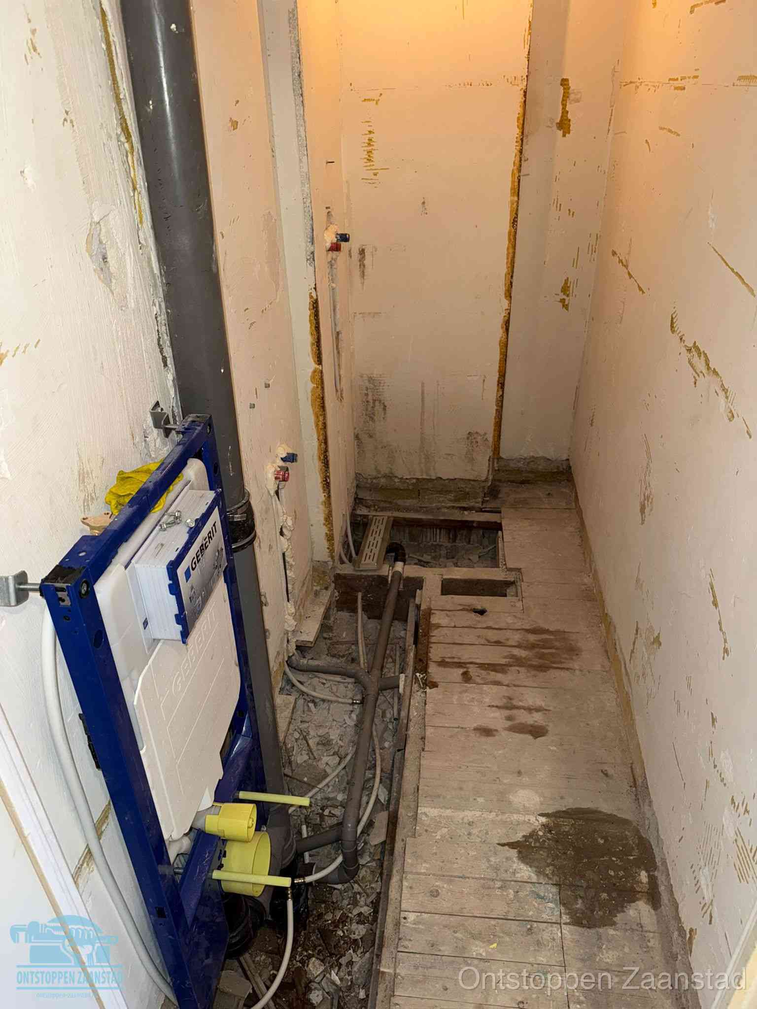 Een opgebroken toiletruimte tijdens renovatie met een Geberit inbouwreservoir en blootliggende oude afvoerleidingen, typisch voor oudere woningen in Zaanstad